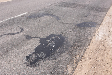 Bad asphalt road, pits, pit repairs.