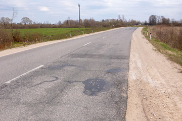 Bad asphalt road, pits, pit repairs.