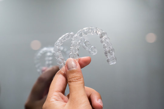 Hand hold inivisalign braces, transparent aligner, invisible retainer or orthodontic silicone trainer. A way to have a beautiful smile.