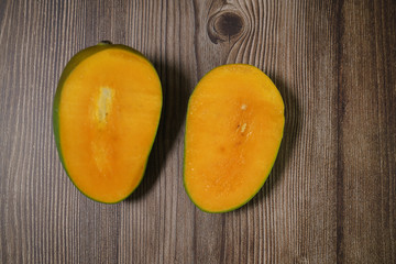 Close up of famous sweet mango in North Malaysia called Harum Manis isolated on top of dark wooden background. Sweet and juicy. Malaysian and Asian favourite mango.