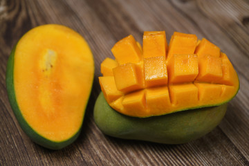 Close up of famous sweet mango in North Malaysia called Harum Manis isolated on top of dark wooden background. Sweet and juicy. Malaysian and Asian favourite mango.