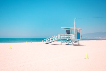 Fototapeta premium Pastel toned Empty beach iwith famous vintage wooden lifeguard hut in Santa Monica