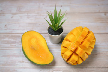 Close up of famous sweet mango in North Malaysia called Harum Manis isolated on top of wooden background. Sweet and juicy. Malaysian and Asian favourite mango.