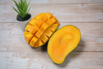 Close up of famous sweet mango in North Malaysia called Harum Manis isolated on top of wooden background. Sweet and juicy. Malaysian and Asian favourite mango.