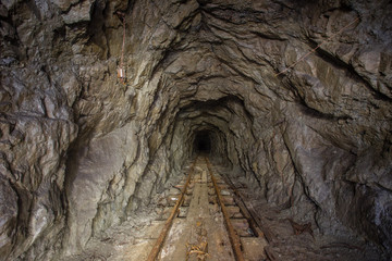 Underground abandoned iron ore mine tunnel with rails