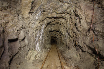 Underground abandoned iron ore mine tunnel with rails