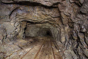Underground abandoned iron ore mine tunnel with rails