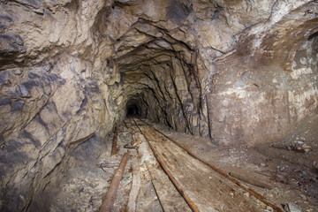 Underground abandoned iron ore mine tunnel with rails