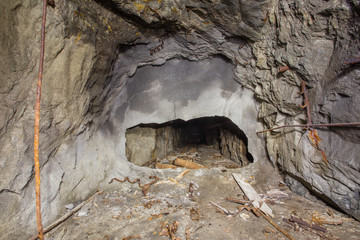Underground old abandoned iron mine tunnel with broken wall