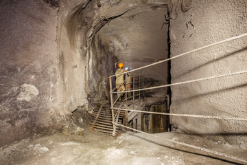Underground old abandoned iron mine tunnel with miners