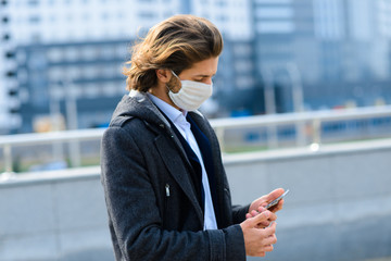 Fototapeta premium Young man in a medical mask outside, no money, crisis, poverty, hardship. Quarantine, coronavirus, isolation.