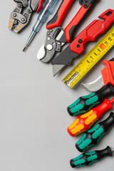 Tools of an electrician-installer or Builder on a gray table. Construction tools for repairs on a gray background. Top view with space for text