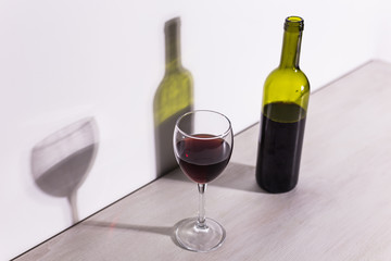 Shadow of wine glass in dark light.
