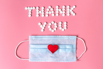 International's nurses day, week concept, Text Thank you by tablets and red heart on pink background.