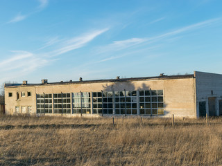 Fototapeta na wymiar Abandoned building in an overgrown field