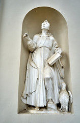 Dusty statue of virgin Mary near the entrance to the church