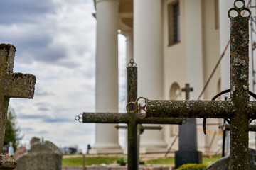 Metal crosses on a graveyard near the big church with pillars