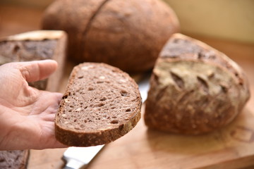 A fresh crusty loaf of homemade bread. Homemade rustic sour bread on a wooden chopping board.
Slice of brown bread. Sliced bread. 