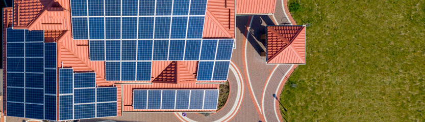 Aerial top view of new modern residential house cottage with blue panels. Renewable ecological...