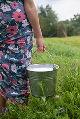 Milkmaid holding bucket with milk