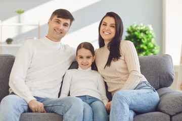 Happy funny family with children smiling sitting on a sofa