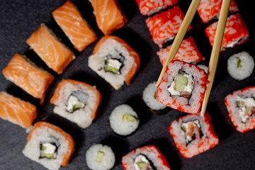 Set of sushi roll on black slate background food fish philadelphia japanese salmon delicious sushi rice cucumber meal traditional wasabi fresh healthy gourmet raw cuisine
