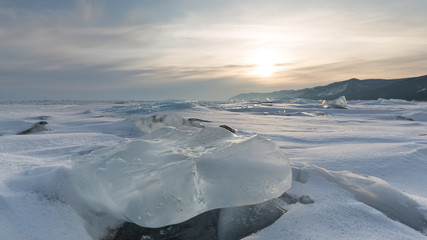 einsame Landschaft mit Eisschollen und Schnee im Winterabendlicht