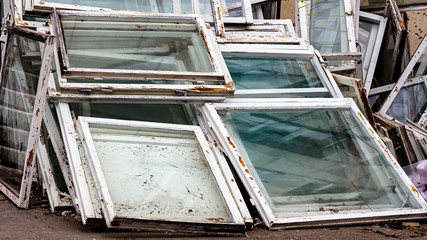 replacing old windows with new ones. discarded broken window frames lie on top of each other.
