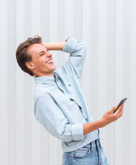  happy young man holding mobile phone and laughing