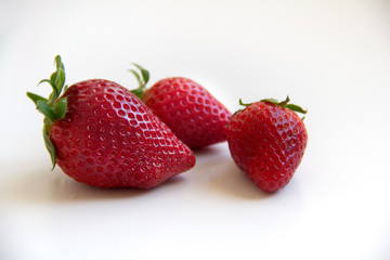 Set of three strawberries on a white background. Three red strawberries