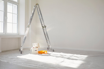Concept painting work repair painting. Ladder paint cans in a white room for repair