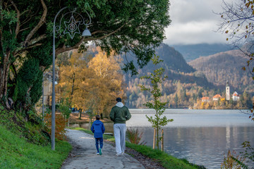 Father and son enjoy in walk by the Bled lake in autumn