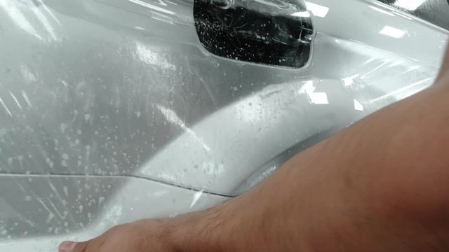 Close up to PPF installation process on silver sports car. PPF is a Paint Protection Film which protect paint from scratches and stone chips.
