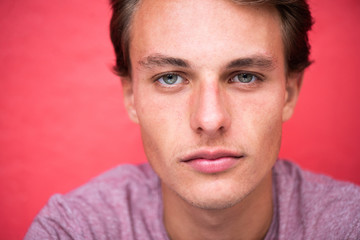 Obraz premium Close up handsome young man staring by red wall