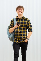 Fototapeta premium happy young man with bag and cellphone by white background