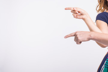 Couple pointing at the left corner with fingers standing isolated over white background. Copy space for product advertisement.