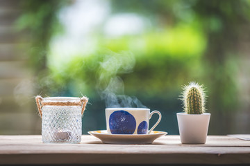 Garden enjoyment concept. Cup of tea, candle and plants on a rustic wooden table, leisure home