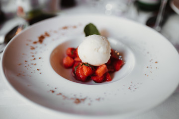 a plate of vanilla ice cream with strawberry