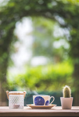 Garden enjoyment concept. Cup of tea, candle and plants on a rustic wooden table, leisure home