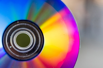Compact Disc. Holding a CD in hands. The back side of the CD reflects colorful lights. Rainbow...
