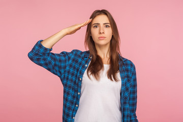 Yes sir! Portrait of patriotic confident young woman in checkered shirt saluting to commander with...