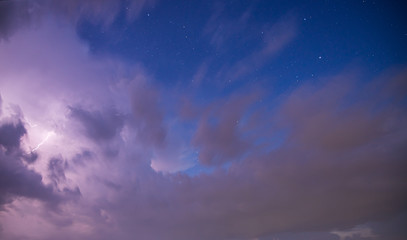 Dramatic storm clouds with blue sky, stars and lightening bolt