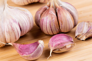 Garlic bulbs and cloves on a wooden cutting board