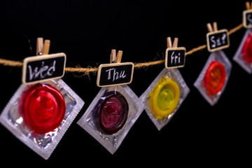 Condoms hanging on string with days of the week