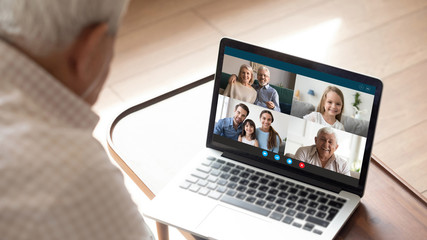 Close up of elderly man talk speak with diverse relatives on video call using modern tablet quarantine at home, mature grandfather have online web conversation conference with family on computer