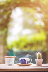 Garden enjoyment concept. Cup of tea, candle and plants on a rustic wooden table, leisure home