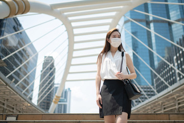 COVID-19 Pandemic Coronavirus Asian Woman in city street going to work. She wearing face mask protective for spreading of disease virus. 