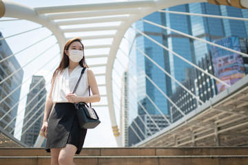 COVID-19 Pandemic Coronavirus Asian Woman in city street going to work. She wearing face mask protective for spreading of disease virus. 