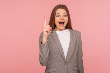 Startup idea! Portrait of inspired excited young woman in business suit gesturing finger up...
