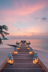 Fotobehang Romantic dinner on the beach with sunset, candles with palm leaves and sunset sky and sea. Amazing view, honeymoon or anniversary dinner landscape. Exotic island evening horizon, romance for a couple  © icemanphotos